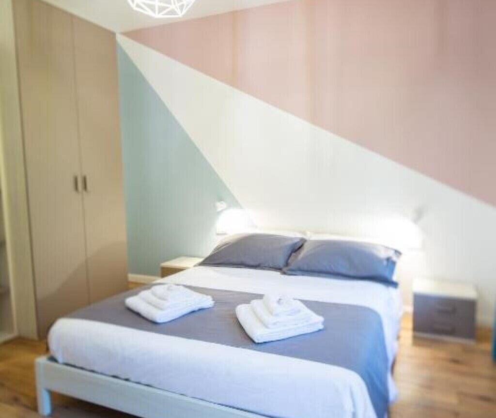 Une chambre à coucher avec un lit, des oreillers et une table de chevet.