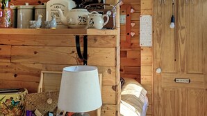 Een houten interieur met een lamp, een mand en een bordje 'WASH ROOM'.