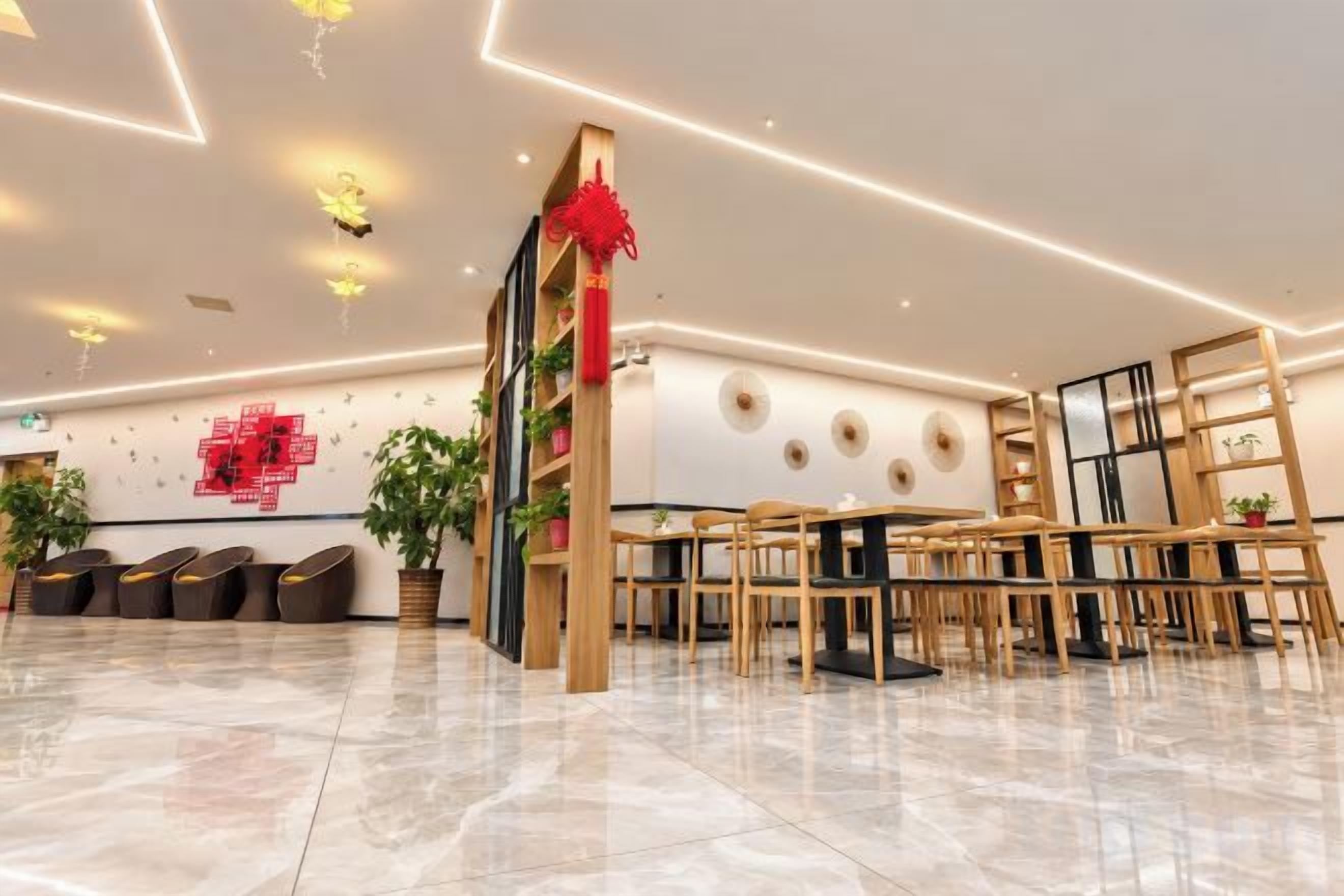 A modern hotel lobby with a seating area, a reception desk, and a decorative wall.