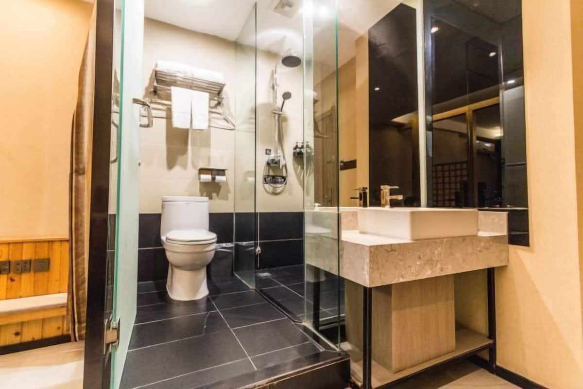 Un bagno moderno con doccia vetro, water bianco e mobile lavabo.