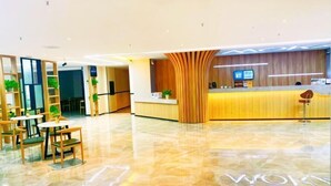 A modern hotel lobby with a reception desk, seating area, and a polished marble floor. - Yanji Moka Boutique Hotel (Yanji)