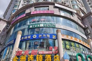 A hotel with a curved facade, multiple signage, and a prominent entrance.