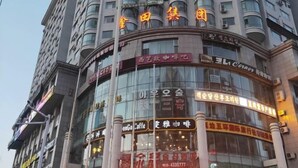 A multi-story building with several commercial establishments on the ground floor, including a cafe and a restaurant. - Yanji Moka Boutique Hotel (Yanji)