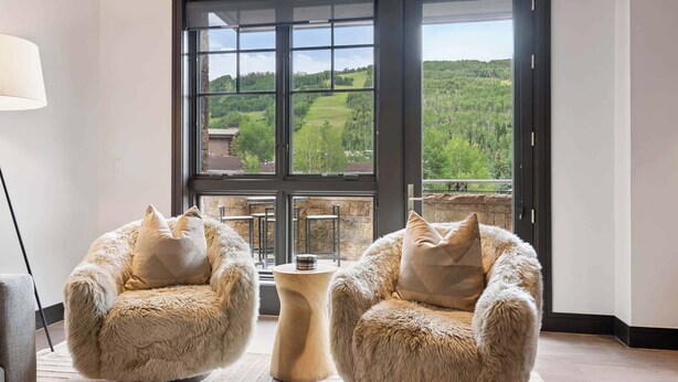 A room with two fur-covered chairs facing a large window with a view of a green landscape. - Solaris 3A East - 3BR (Vail)