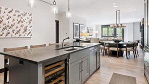 A modern kitchen with a central island, pendant lighting, and a dining area with a round table and chairs. - Solaris 3A East - 3BR (Vail)