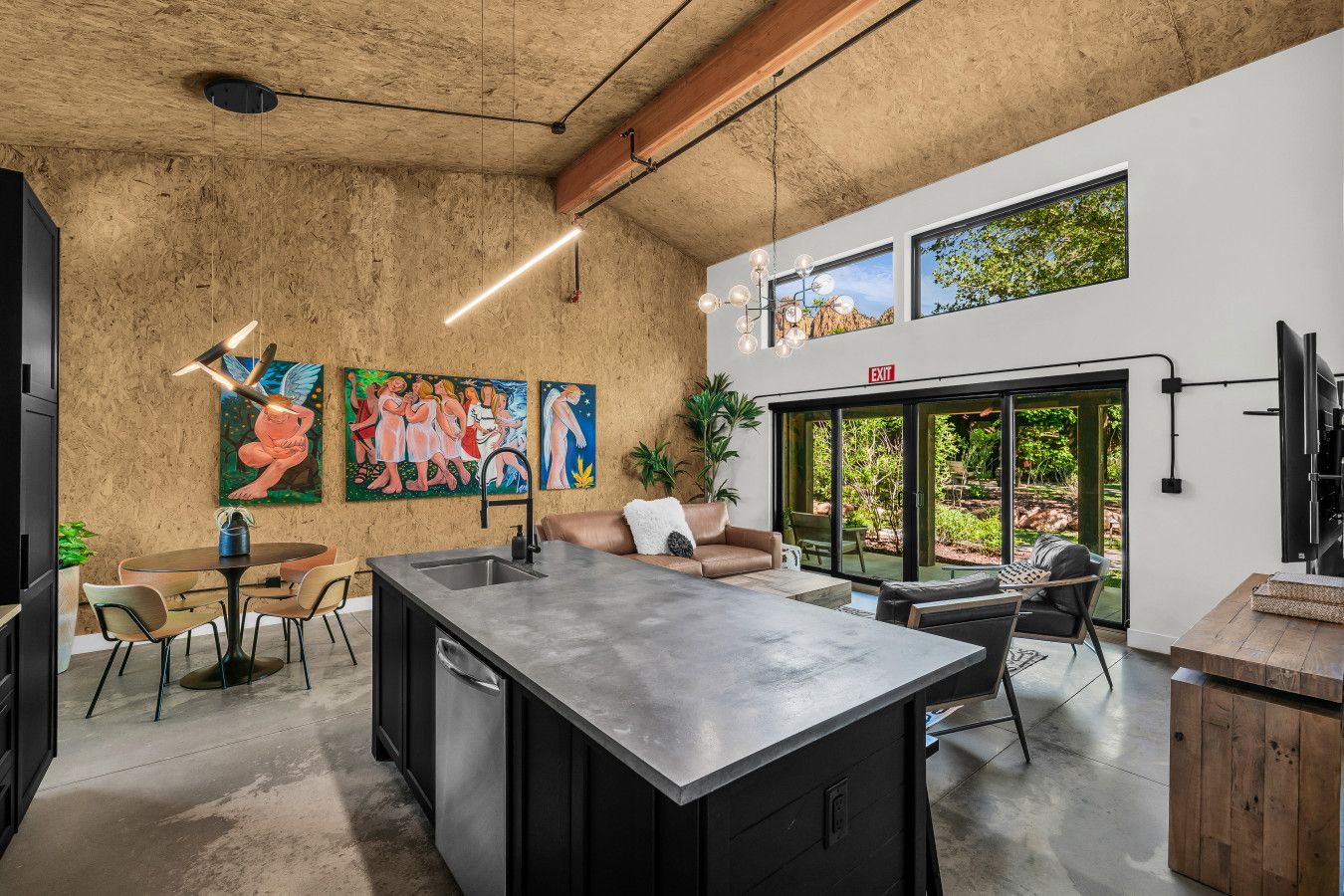 Een moderne keuken met een groot eiland, een eethoek en kunstwerken aan de wanden.