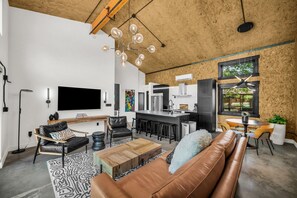 A modern living room with a leather sofa, a coffee table, and a TV.