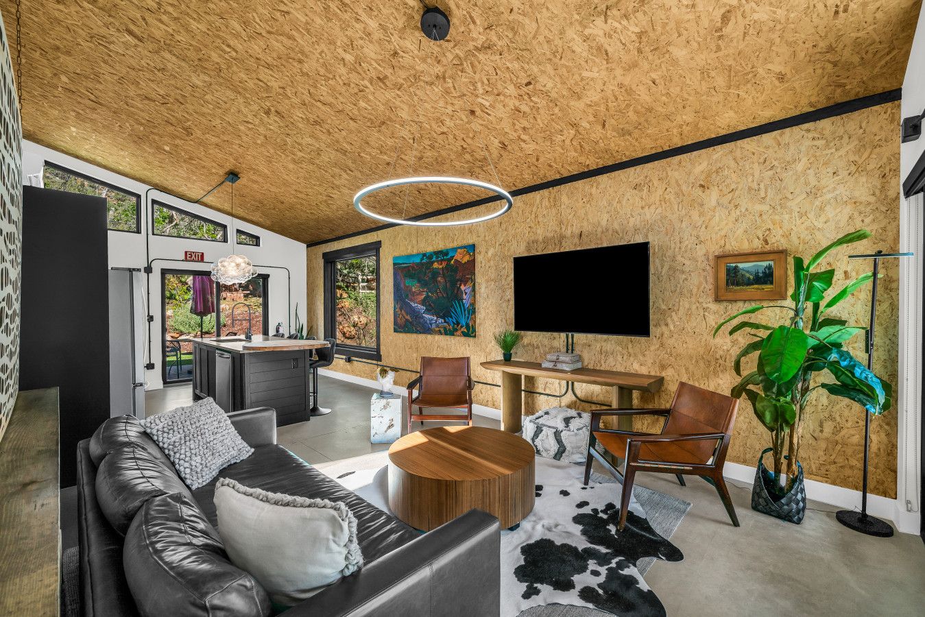 Ein modernes Wohnzimmer mit einer Couch, einem Couchtisch und einem an der Wand befestigten Fernseher.