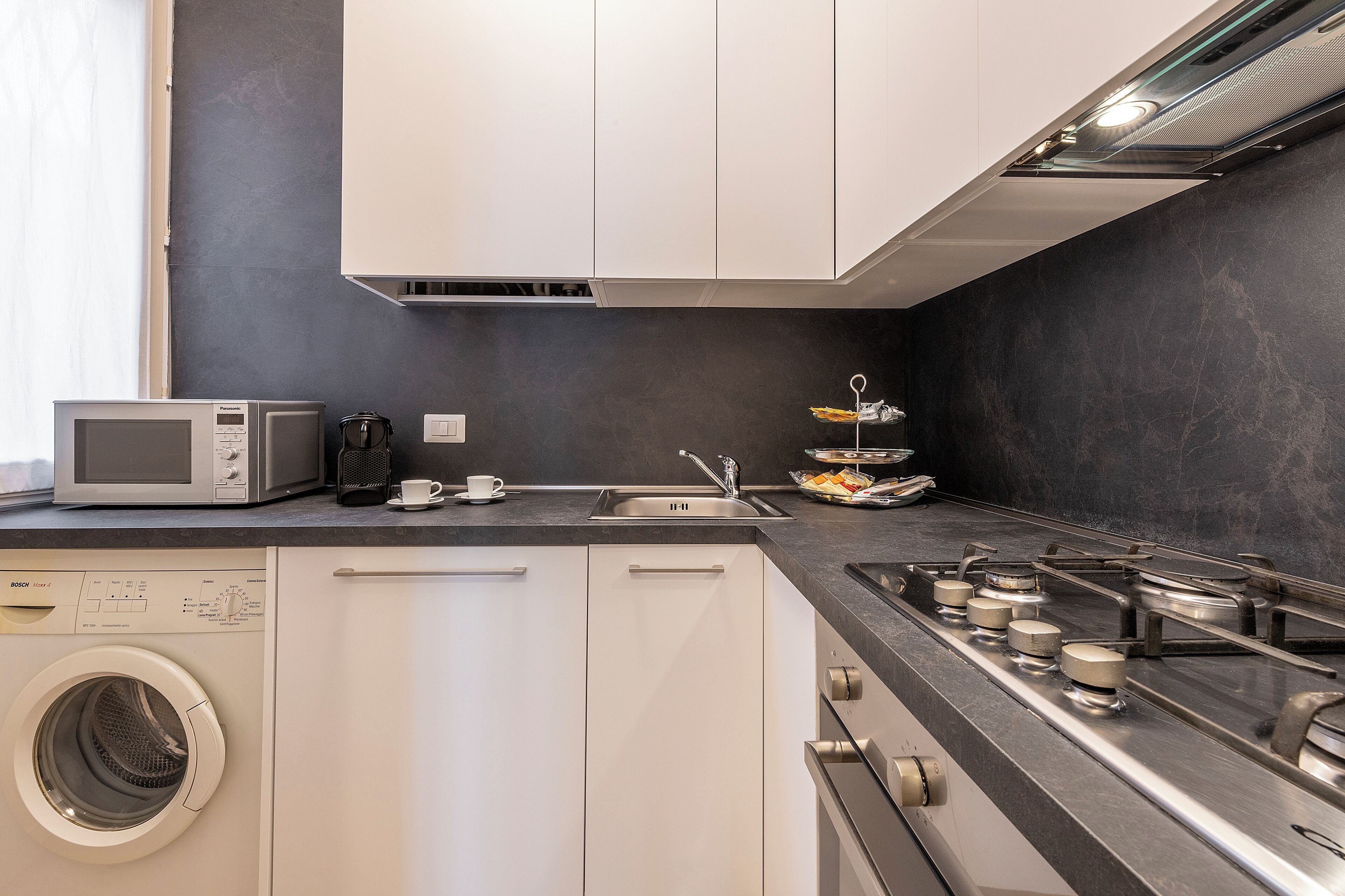 A compact kitchen with a microwave, sink, and stove.
