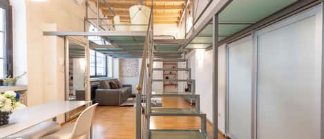 Een modern interieur met een trap, houten vloeren en een eetgedeelte met witte meubels.