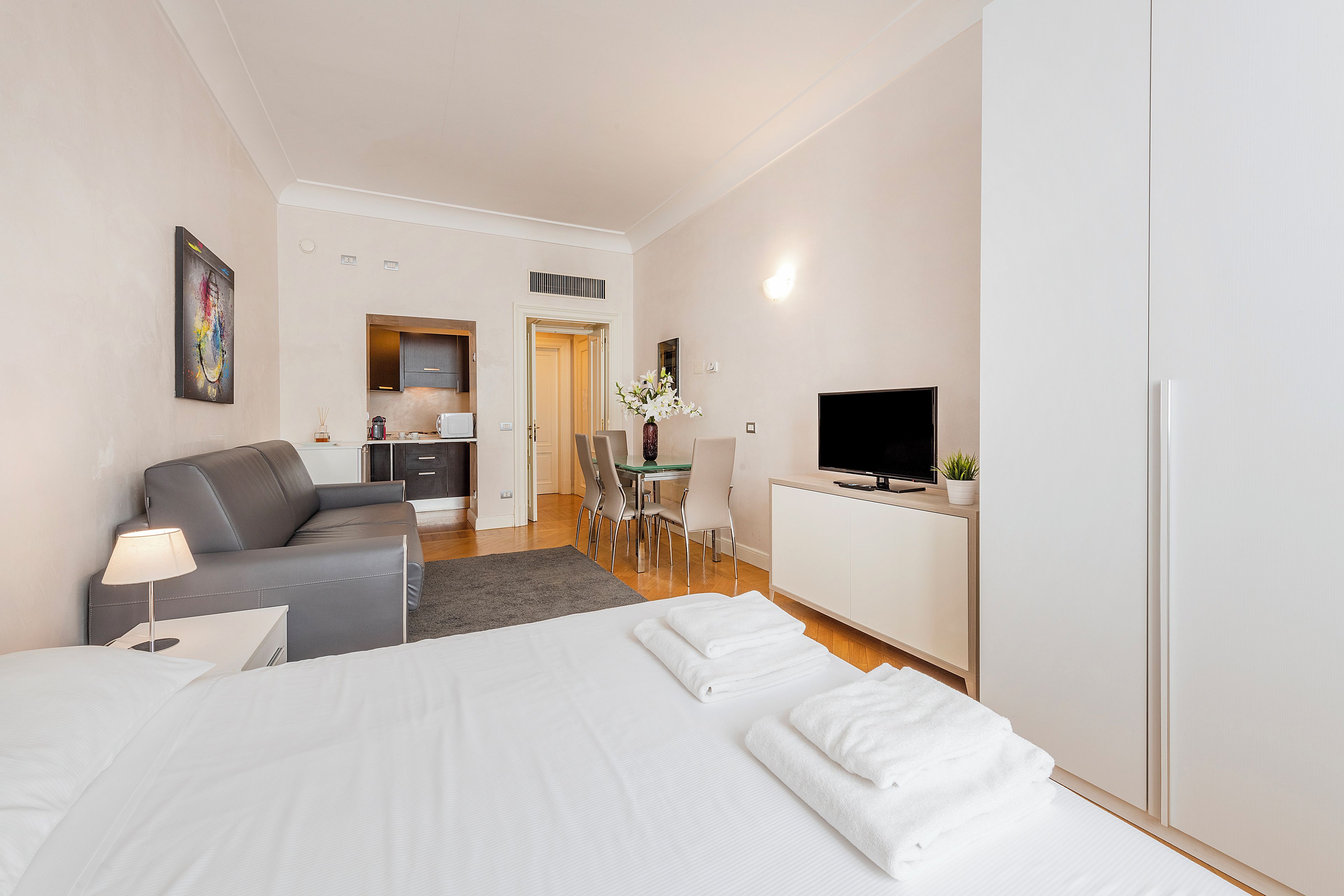 Ein Hotelzimmer mit Bett, Schreibtisch, Fernseher und Essbereich.