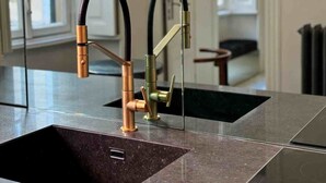A modern kitchen with a large sink, copper faucet, and a glass backsplash. - Milan Royal Suites - Brera (Milan)