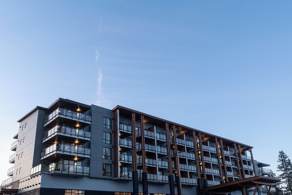 A multi-story hotel with balconies and large windows.