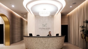 Ein Empfangsschalter mit einem Logo, einer Chandelüster und einer Pflanze.