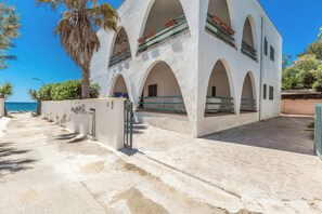 Un bâtiment doté de plusieurs arcades et d’une entrée pavée de pierres.