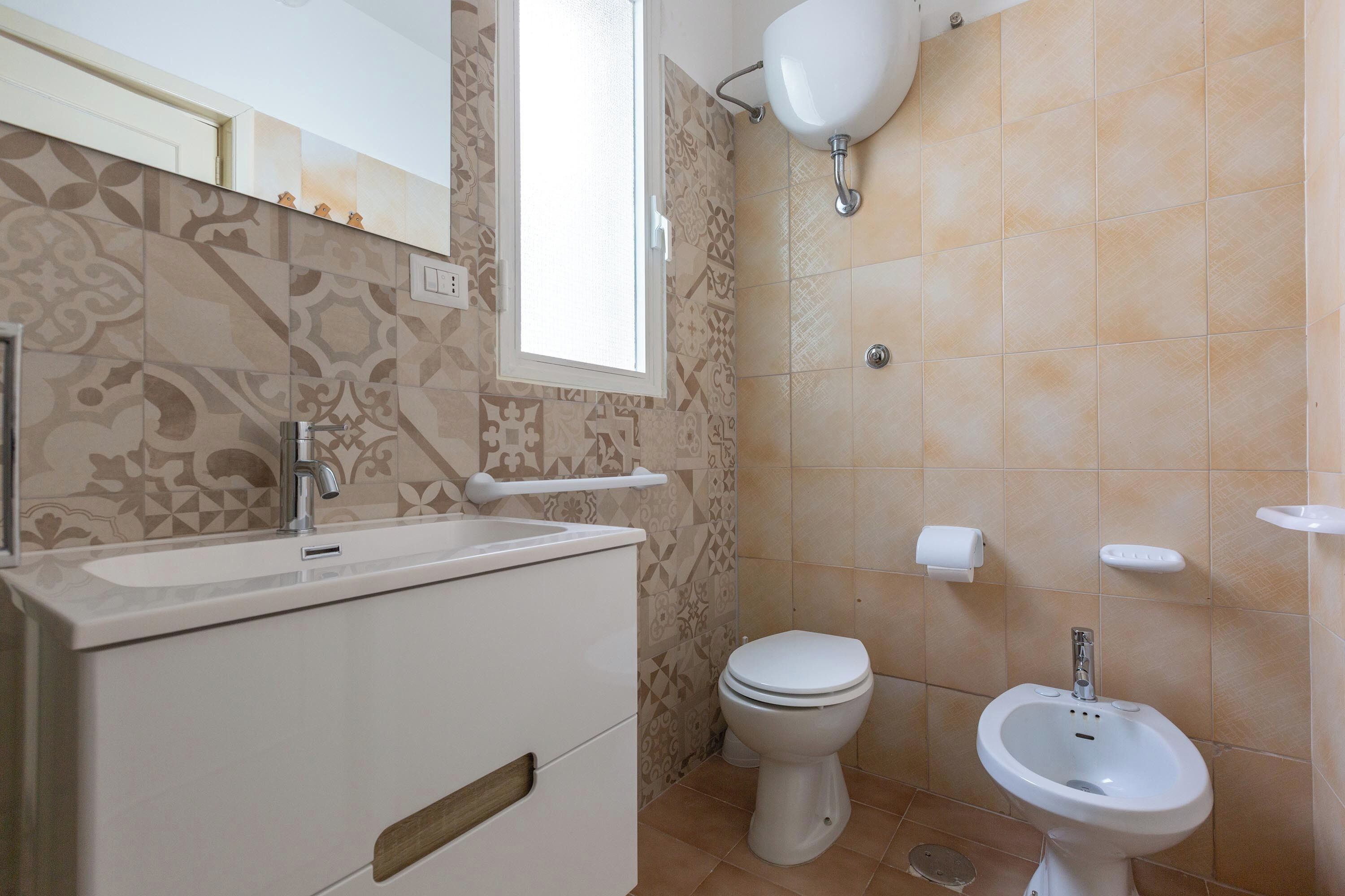 A bathroom with a toilet, bidet, and sink.
