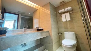 A modern bathroom with a large mirror, a marble countertop, a toilet, and a towel rack. - ChangSha Sanhe Hotel (Changsha)