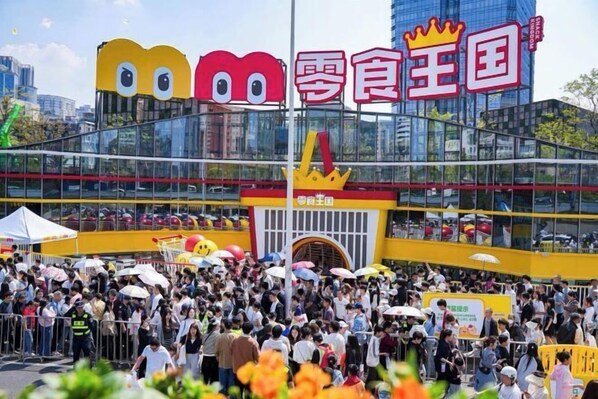 A crowded outdoor area with a large building featuring a distinctive yellow and red design. - ChangSha Sanhe Hotel (Changsha)