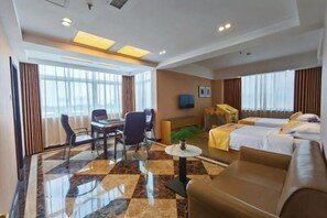 A hotel room with a bed, a sofa, a desk with chairs, a television, and large windows. - ChangSha Sanhe Hotel (Changsha)