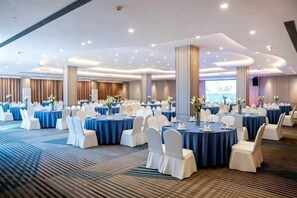 A banquet hall with round tables, white chairs, and blue tablecloths. - ChangSha Sanhe Hotel (Changsha)