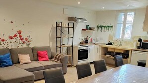 A modern living room with a sofa, a dining table, and a kitchen area. - Provencal house for 14 sleeps with private garden. Perfect for family gatherings (La Crau)