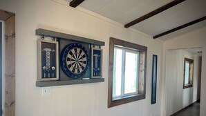 A hallway with a dartboard, a window, and a door. - The Man Cave. Perfect for traveling workers and a great place for families  (Greybull)