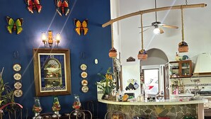 A dining area with a round table, chairs, and a kitchen area with stools. - Casa de Campo (El Valle de Antón)