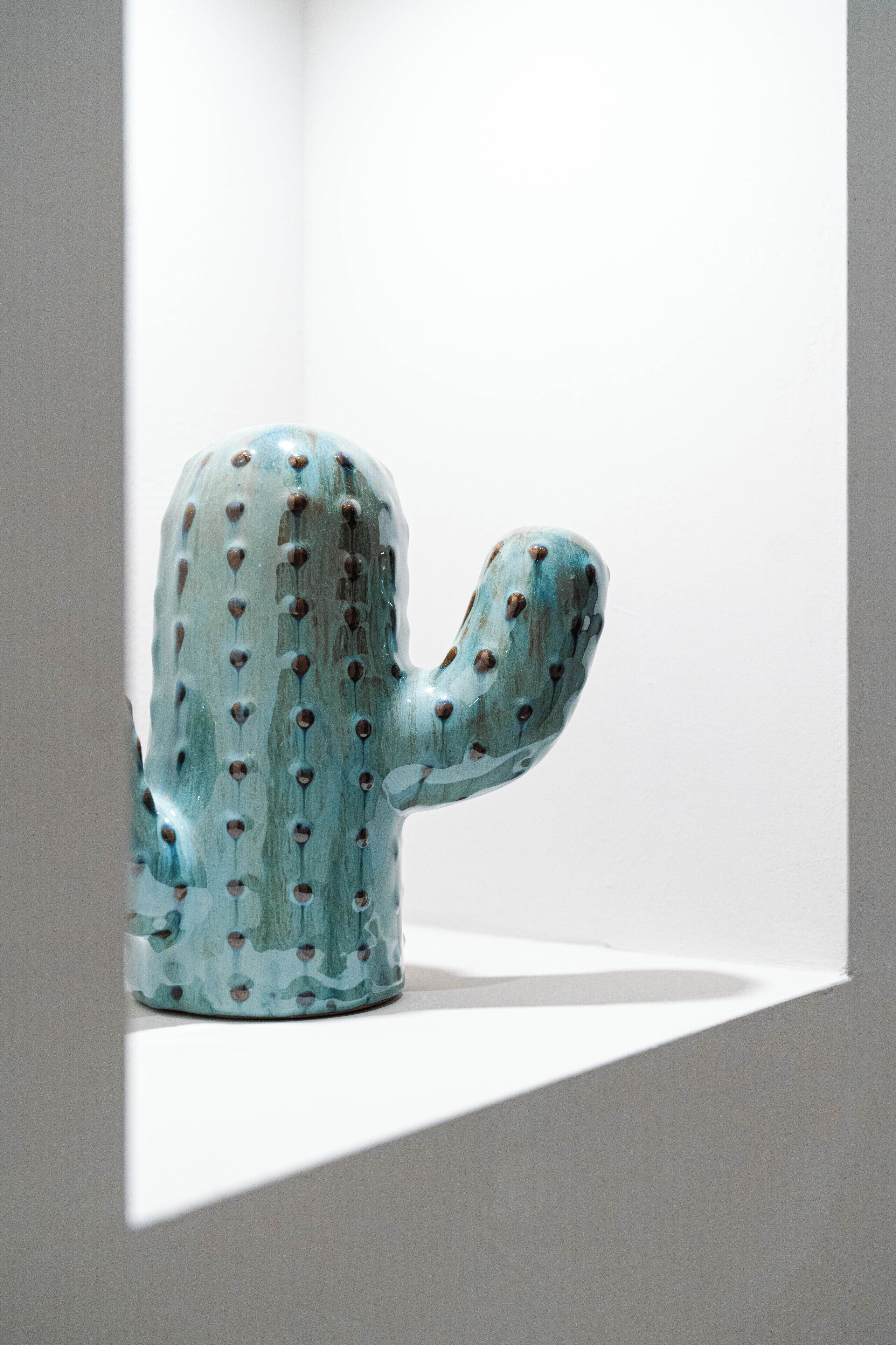 Une sculpture en forme de cactus, placée dans un coin.