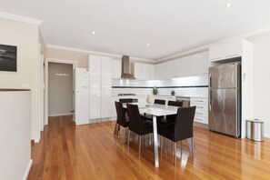 Enjoy meals in the kitchen with a central island and dining area, featuring a table and chairs.