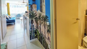 A hotel room with a mural of a historic building, a bed, a desk, and a chair. - Balcis Apartment by Hello Homes Sitges (Sitges)