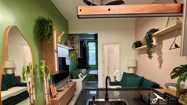 Una cocina moderna con encimera negra, armarios de madera e instalación para lavamanos.