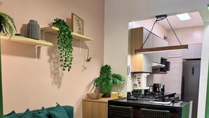 A modern kitchen with a built-in island, wooden cabinets, and a stainless steel refrigerator. - No Coração do Flamengo, a Poucos Passos do Metrô e bem Equipado (Flamengo Rio de Janeiro)