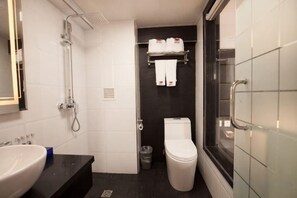 A bathroom with a toilet, sink, shower, and a towel rack with towels. - Watermelon Hotel (Dalian Zhongshan Square Railway Station Store) (Dalian)