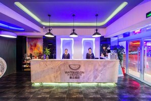 A reception desk with a marble top and two attendants. - Watermelon Hotel (Dalian Zhongshan Square Railway Station Store) (Dalian)