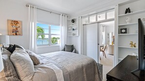 Ein Schlafzimmer mit einem großen Bett, einem Fernseher und Blick ins Freie.