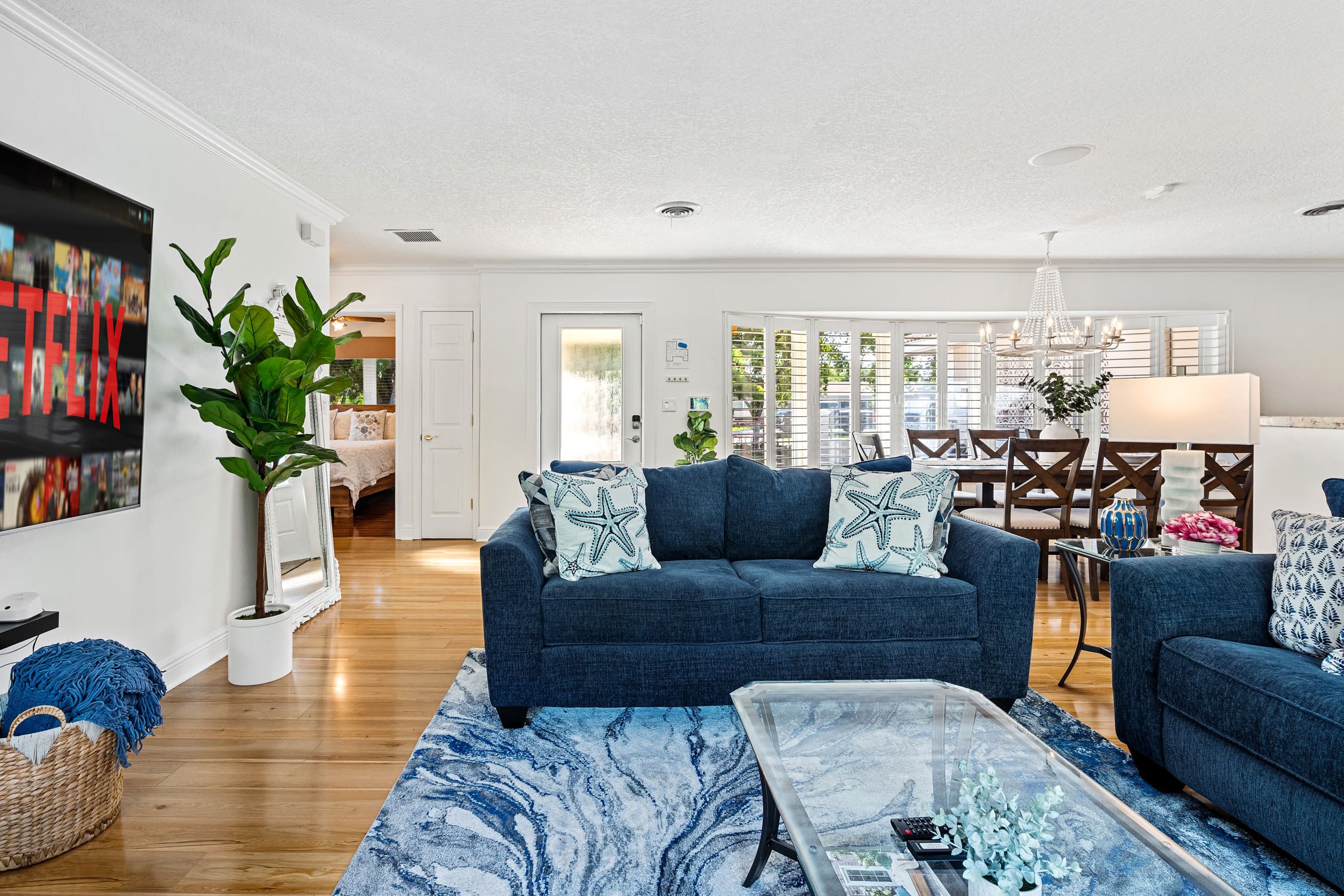 A living room with a blue sofa, a coffee table, and a large plant.
