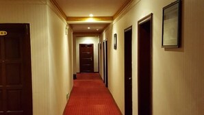 A hotel hallway with a red carpet, wooden doors, and framed pictures on the walls. - Yongzhou Haolaiwu Riverview Hotel (Yongzhou)