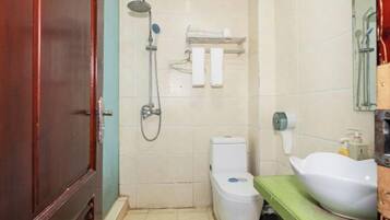 A bathroom with a shower, toilet, sink, and towel rack.