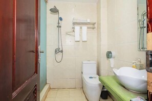 Un baño con ducha, inodoro, lavabo y toallero.