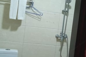 Un baño con inodoro, perchero y ducha.