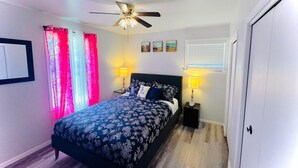 A bedroom with a bed, two bedside lamps, a ceiling fan, and a window with blinds. - Beautiful house//self check in//7 mins to YEG Airport//Nature walk🌴 (Leduc)