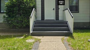 A two-story building with a white door and a sign reading "SKYNEST INN". - Beautiful house//self check in//7 mins to YEG Airport//Nature walk🌴 (Leduc)
