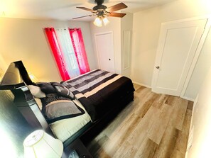 Cozy retreat with a single bed, ceiling fan, and lamp.