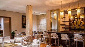 A hotel lobby with patterned sofas, a bar area with stools, and hanging lamps. - Al Destino Luxury Villa & Spa Marrakech (Oulad Hassoune)
