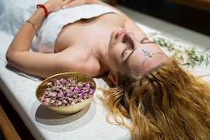 A person lying on a massage table with a bowl of dried flowers beside them. - Al Destino Luxury Villa & Spa Marrakech (Oulad Hassoune)