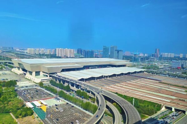 An aerial view of a modern train station with multiple tracks and a large building with a flat roof. - JI Hotel (Zhengzhou East Railway Station) (Zhengzhou)