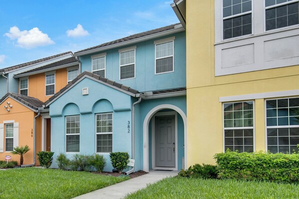 A row of townhouses with a front entrance, a small garden, and a clear blue sky. - 4 BD/ 3.5 BA/ The Enclaves at Festival (382 CD) (Davenport)