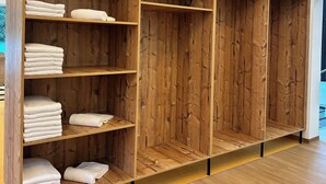 Un armario de madera con varios estantes, algunos con toallas dobladas.