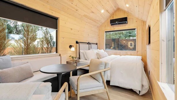 Una habitación acogedora de estilo cabaña, con una cama, una mesita y una silla.
