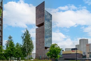 En modern byggnad med en unik arkitektonisk design, som kännetecknas av ett markant vertikalt element och en glasfasad.